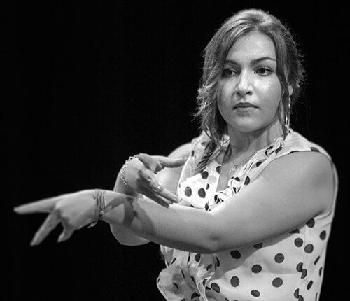 Gros plan sur le visage et les mains d’une danseuse flamenco